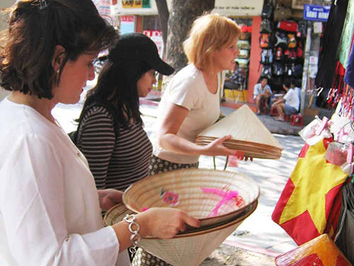 Trong thời gian tới, du khách quốc tế đến Việt Nam, Thái Lan và Campuchia có thể sẽ chỉ dùng chung 1 visa. Trong ảnh: Du khách nước ngoài mua quà lưu niệm tại Hà Nội
