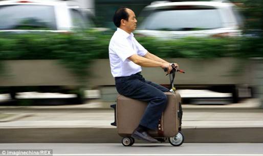 Ông He Liangcai đang “cưỡi” trên chiếc xe va-ly từ nơi làm việc để về nhà.