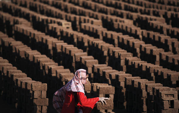 Một phụ nữ Pakistan đang xếp gạch tại một nhà máy gạch ở ngoại ô Islamabad, Pakistan 