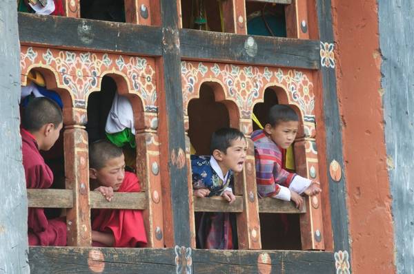  Trẻ em Bhutan đang xem trò chơi bóng đá từ cửa sổ của một tu viện. Ảnh: Margot Raggett