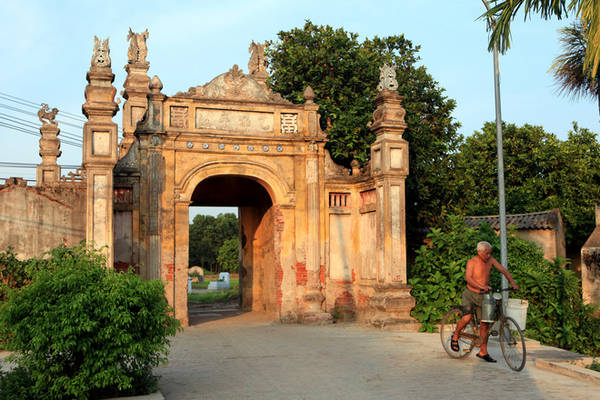 Cổng làng bề thế, được xây dựng cách đây hơn 200 năm với bốn trục vuông chạm khắc nhiều họa tiết tinh xảo. Sau cánh cổng, làng Nôm hiện lên hệt như những gì người ta vẫn hình dung về ngôi làng Việt cổ.