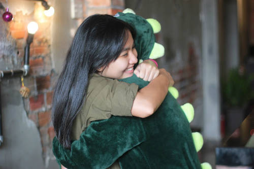 Một vị khách ôm lấy con khủng long thật chặt. 