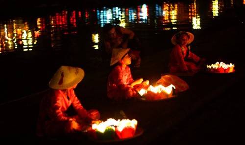  Những cô bé, cậu bé bán hoa đăng cho khách du lịch thả xuống sông Thu Bồn. 