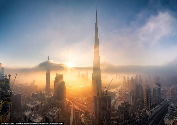 Khung cảnh thành phố thay đổi khi có sương bao phủ, trở nên bình yên và siêu thực trong ánh mặt trời.
