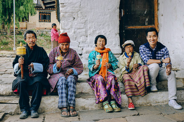 Nguyên Khang chụp ảnh cùng với những người dân Bhutan. Trên tay họ đang cầm Kim Luân Chuyển Chú – một tín vật của Phật Giáo Bhutan. Người già ở Bhutan thường dành thời gian đi đến chùa đọc kinh và thực hiện đều đặn mỗi ngày. Nguyên Khang chụp ảnh cùng với những người dân Bhutan. Trên tay họ đang cầm Kim Luân Chuyển Chú – một tín vật của Phật Giáo Bhutan. Người già ở Bhutan thường dành thời gian đi đến chùa đọc kinh và thực hiện đều đặn mỗi ngày.