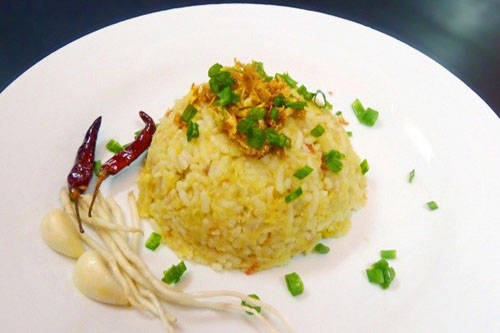 Nga htamin (cơm cá): Món này được nấu chín gạo với nghệ tươi, phủ lên bằng một lớp da cá và dầu tỏi. Món cơm cá ăn kèm với tóp mỡ rán giòn mang lại hương vị béo ngậy và thơm ngon. Ảnh: Saffrontravel.