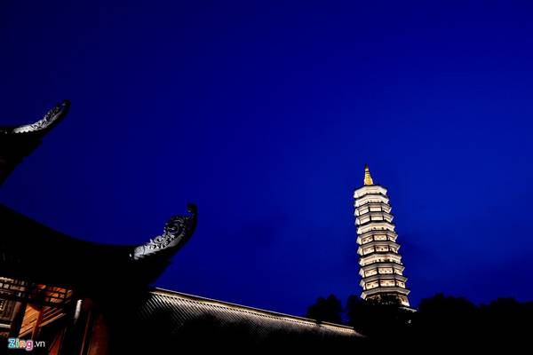 Bảo tháp cao nhất Đông Nam Á (100 m) tại chùa Bái Đính rực sáng về đêm. Để lên được đây, du khách phải ngồi trên xe điện hoặc leo bộ qua hành lang La Hán hai bên khuôn viên chùa.