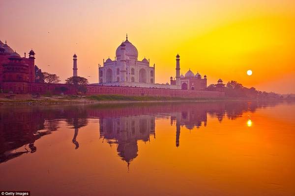 Khi mặt trời lặn sau lăng Taj Mahal của Ấn Độ, các mái vòm và tường cẩm thạch của công trình tuyệt mỹ này chuyển màu tím, giữa không gian lộng lẫy với ánh nắng màu cam ấn tượng. 