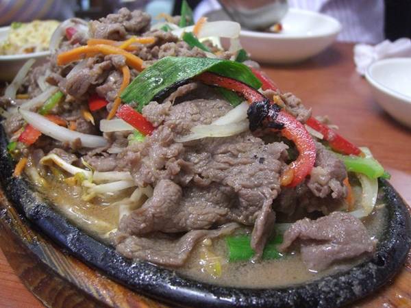 Bulgogi là thịt bò thái mỏng được rưới nước sốt xì dầu ngọt, sau đó nướng cùng ớt, hành và giá.