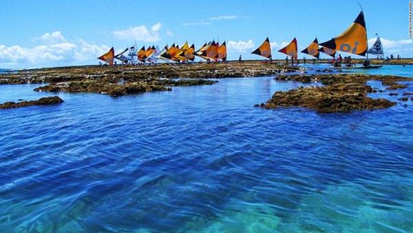 Porto de Galinhas là một trong những bãi biển đẹp nhất Brazil. Những làn nước trong vắt là thiên đường cho những ai thích bơi và lặn tự do. Khi thủy triều xuống thấp, du khách có thể đi thuyền "Jangada" để ngắm cá đang bơi lội trong những rạn san hô. Ảnh: CNN.