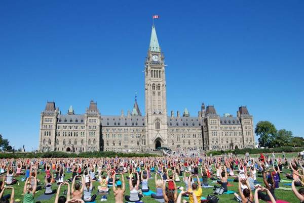 Tập yoga tại Parliament Hill, Ottawa: The Hill thu hút 3 triệu du khách mỗi năm. Vào giữa trưa các ngày thứ 4 suốt mùa hè, ở đây tổ chức tập yoga miễn phí trên sân cỏ. Ảnh: Ottawa Tourism.