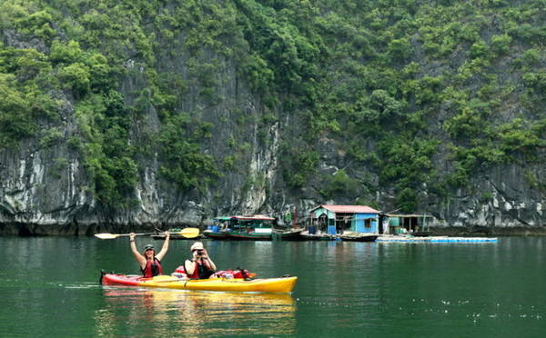 Du khách chèo thuyền kayak trên vịnh Lan Hạ - Ảnh: ĐỨC HÙNG