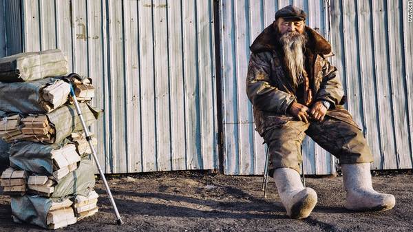 Bức ảnh Paul Cox chụp một cụ già ở Mông Cổ. “Mùa đông, lạnh -15 độ, cụ già bán gỗ mang đôi giày len để giữ ấm. Mùa đông ở Ulaanbaatar rất ô nhiễm vì khói do người ta đốt than và gỗ”, anh viết.