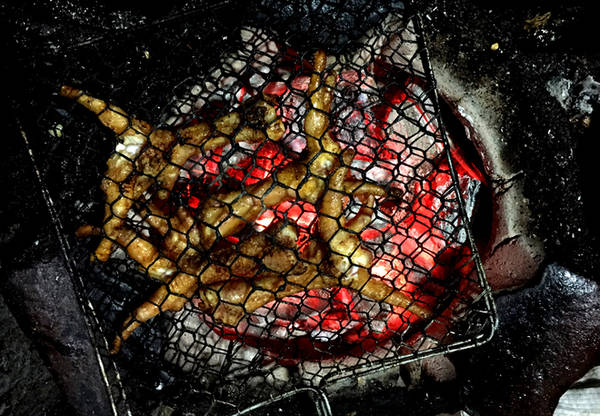 Chân gà sẽ được nướng đến khi cháy vàng trên lửa than, nhưng trước đó chủ quán đã tẩm ướp và nướng qua. Khi khách đến gọi, chân gà được kẹp vào vỉ kim loại và nướng trên bếp than hồng.