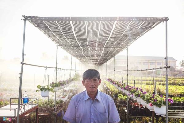 Ông chủ vườn hoa Hai Cao có diện tích hơn 1 ha đứng trước những luống hoa được tưới nước tự động.