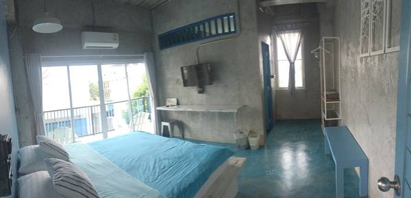 Phòng có tone màu trắng/xanh, tường màu xi măng.