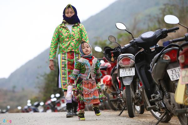 Những cô bé người Mông được cha mẹ cho mặc đồ thật đẹp, rực rỡ sắc màu để đi du xuân.