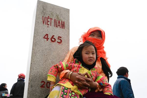 Em bé Mông trong vòng tay mẹ chụp ảnh bên cột mốc biên giới 465.