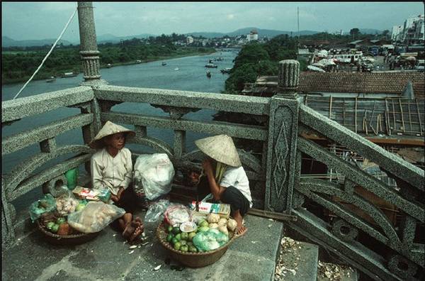 Hai phụ nữ bán hàng rong bên bờ sông Ka Long ở Móng Cái, bên kia sông là lãnh thổ Trung Quốc, 1995.