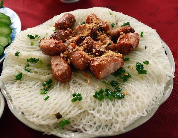 Một dĩa bánh hỏi mặt võng được xếp ăn kèm với thịt nướng kim tiền sẵn sàng phục vụ thực khách.