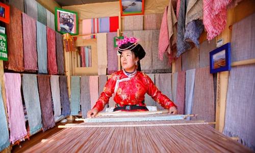 Phụ nữ Mosuo dệt vải trong cửa hàng ở Lệ Giang, Trung Quốc. Ảnh: Chien-min Chung. Phụ nữ Mosuo dệt vải trong cửa hàng ở Lệ Giang, Trung Quốc. Ảnh: Chien-min Chung.