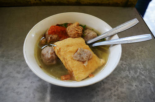 Bakso (Thịt viên) Bakso hay súp thịt viên là một trong những món ăn du khách có thể tìm thấy ở khắp nơi tại Indonesia, từ các xe bán hàng rong đến nhà hàng lớn. Thịt viên thường được làm từ hỗn hợp thịt bò xay và bột sắn, nhưng cũng có loại được làm từ thịt gà, cá hoặc tôm, thậm chí thịt trâu. Tô súp thịt viên nóng hổi mang ra cho thực khách với nước dùng được nấu từ bò hoặc gà, ăn kèm với mì sợi, giá đỗ, đậu phụ và hành lá. Món ăn sẽ ngon hơn nếu cho thêm chút ớt tươi hoặc tương ớt. Malang và Solo là 2 thành phố có món bakso ngon bậc nhất ở Indonesia. Giá phổ biến cho một tô bakso từ 10.000 rupiah (17.000 đồng). Ảnh: Phong Vinh.