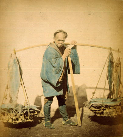 Một ngư dân với gánh cá hồi khô và cá ngừ.