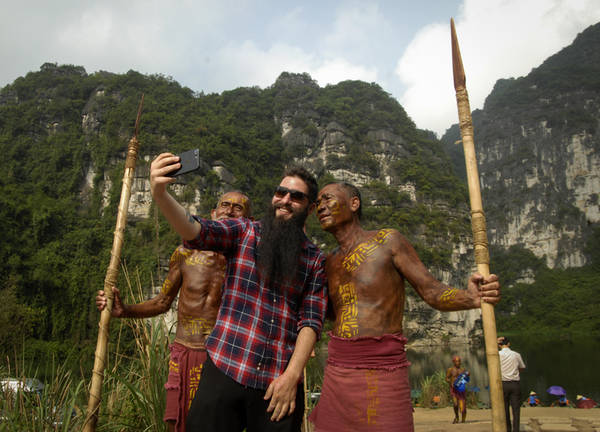Trong chuyến đi này, Đại sứ du lịch muốn gặp gỡ và thăm lại những người dân từng ghi hình cho bộ phim. Trong hình, anh hào hứng chụp ảnh selfie với những người dân hóa trang thành dân làng trong phim trường.
