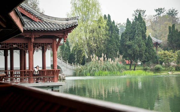 Một cô gái nghỉ ngơi bên hồ trong công viên gần đền tưởng niệm Vũ Hầu. Thành Đô có nhiều quán trà, công viên và các hoạt động, tạo bầu không khí vui vẻ và thoải mái cho du khách cũng như người dân.