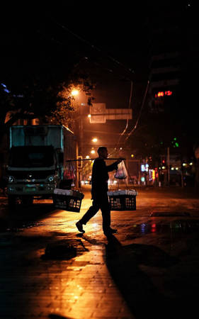 Người đàn ông gánh hàng bán rong trên đường phố đêm ở Thượng Hải