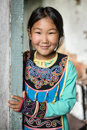 Một cô bé người Uilta ở đảo Sakhalin. Siberia mỉm cười khi Khimushim chụp chân dung em trong trang phục truyền thống. Một số người Uilta cao tuổi được sinh ra vào thời điểm một phần đảo Sakhalin thuộc về Nhật Bản, có tên và họ của người Nhật.
