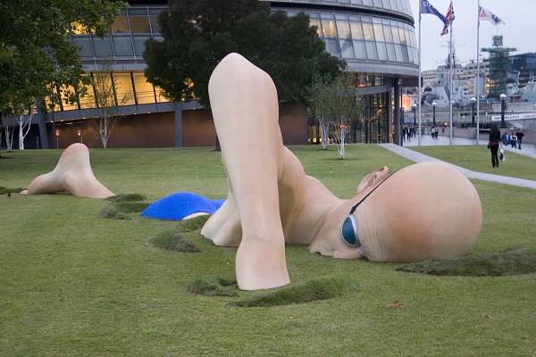 Tác phẩm "Vận động viên bơi lội" ở Anh. Ảnh: Top Sidez Tác phẩm "Vận động viên bơi lội" dài 14m và cao 3m bơi qua bãi cỏ đặt bên bờ sông Thames (Anh). Bức tượng này cùng bức tượng một cô gái kẹt đầu trong cửa hàng tạp hóa được ra mắt năm 2007. Cả hai bức tượng đều in hình xăm trên lưng, là một phần trong chiến dịch quảng cáo của chương trình thực tế London Ink trên kênh Discovery.