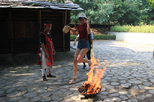 Du khách được hướng dẫn nhảy qua bếp lửa để xả xui trước khi vào khu vực văn hóa Atayal - Ảnh: Ngọc Đông
