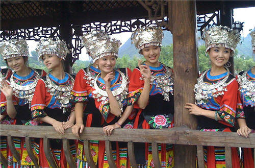 Những cô gái Thổ Gia mặc trang phục truyền thống được nhiều du khách xin chụp hình lưu niệm cùng. Ảnh: Xinhua.
