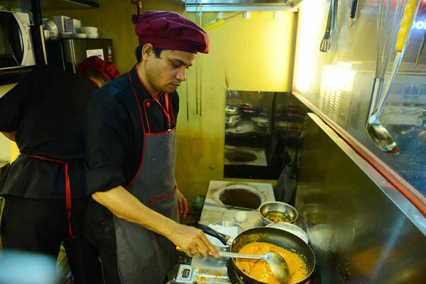 Đầu bếp người Ấn Độ chế biến món ăn để bán khách trong khu ẩm thực. Ảnh: QUANG ĐỊNH
