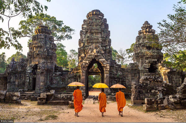 Angkor Wat, Campuchia: UNESCO đánh giá khu vực này là một trong những khu khảo cổ quan trọng nhất ở Đông Nam Á. Ba nhà sư che ô đi bộ tại một trong những ngôi đền có giá trị lịch sử lâu nhất và được tôn kính nhất.