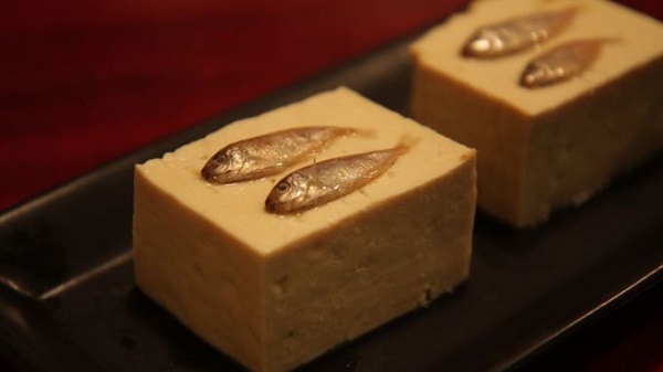 Sukugarasu Là những miếng đậu phụ chắc, kèm những con cá nhỏ xíu bên trên, món sukugarasu rất phổ biến ở Okinawa và thường dùng khi thưởng thức rượu sake hay awamori. Mỗi phần đậu được cắt vừa một miếng ăn và vị mặn đậm của cá thì hòa hợp với sự mềm mại của miếng đậu phụ.