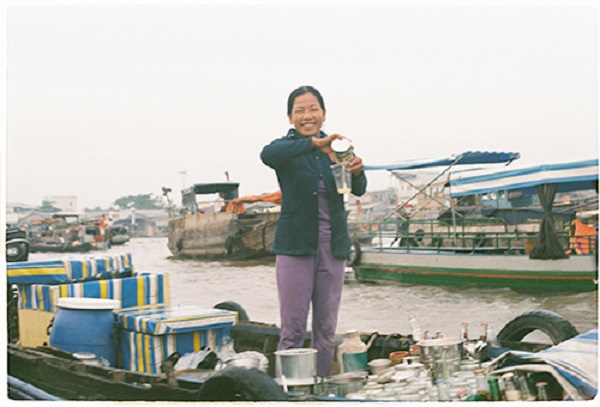 Không sợ sông nước xô đẩy, các chị vẫn có thể đứng và chế cà phê cho khách. Ảnh: Phong Vinh.
