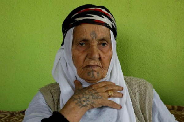 Ayse Yusufoglu, 84 tuổi, chia sẻ về hình xăm trên mặt và tay bà tại nhà ở làng Alukus, gần Kiziltepe, một thị trấn thuộc tỉnh Mardin, Thổ Nhĩ Kỳ. Ảnh: Ảnh: REUTERS/Umit Bektas.