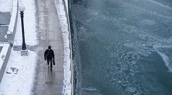 Người đi bộ dọc sông Chicago, một bên phủ tuyết còn một bên dòng sông đã đóng băng do nhiệt độ xuống thấp.