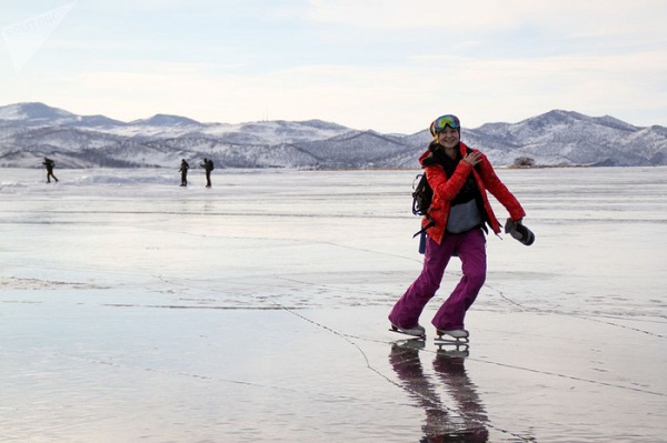 Một nữ du khách hào hứng chơi trượt băng trên hồ Baikal đóng băng - Ảnh: Sputnik/Kirill Shipitsyn