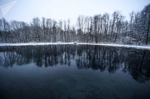 Những hàng cây phủ tuyết trắng soi bóng trên mặt hồ Xanh - Ảnh: Sputnik/Maksim Bogodvid