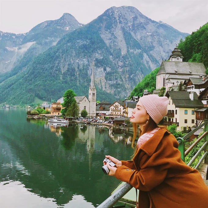 Rời Hà Lan, Linh Phi tiếp tục di chuyển đến Áo để thăm ngôi làng Hallstatt - viên ngọc quý của quốc gia châu Âu này. Có lẽ không phải giới thiệu nhiều bởi lẽ bất cứ ai đặt chân tới Áo cũng ao ước được ghé thăm ngôi làng đẹp tựa tranh vẽ, soi bóng xuống mặt hồ, bốn bề là núi non hùng vĩ. Nằm giữa hai thành phố Salzburg và Graz ở khu hồ Salzkammergut, ngôi làng còn được UNESCO công nhận là di sản văn hoá thế giới cũng như được đánh giá là một trong 20 thị trấn đẹp nhất châu Âu.