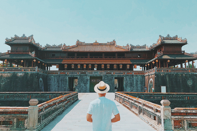 Tý tạo dáng trước Cửa Ngọ Môn - di tích biểu tượng, lớn và đẹp nhất của kinh đô Huế. Chàng trai thích chụp hình sau lưng, người hướng về các công trình cổ của Huế.
