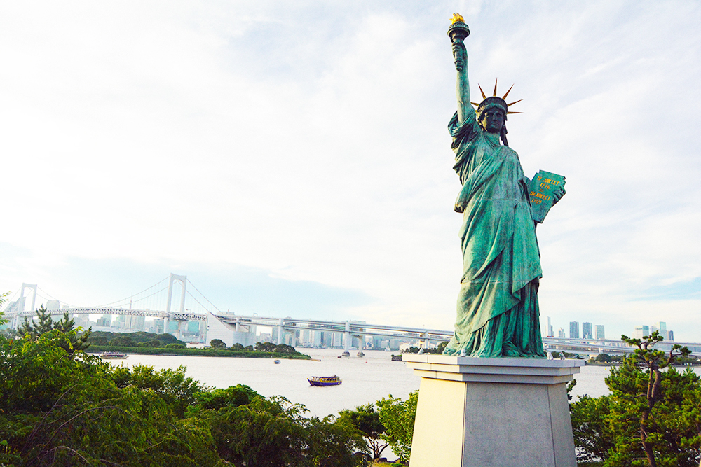 Ở Odaiba, có một địa danh bạn không thể không check in, đó là tượng Nữ thần tự do phiên bản mini, được mô phỏng y chang phiên bản gốc ở Mỹ. Bức tượng này có lịch sử khá thú vị. Năm 1889, chính quyền Mỹ đã dành tặng cho chính phủ Pháp bức tượng mini Nữ thần tự do đặt ở đảo Cygnes bên bờ sông Seinne (Paris). Sau đó, vào năm 1999, bức tượng được đưa đến Nhật trưng bày để kỷ niệm tình hữu nghị Pháp - Nhật. Tới gần ngày trả lại, do được người dân Nhật yêu mến, chính phủ Nhật đã quyết định làm bức tượng mô phỏng và hoàn thành vào năm 2000.