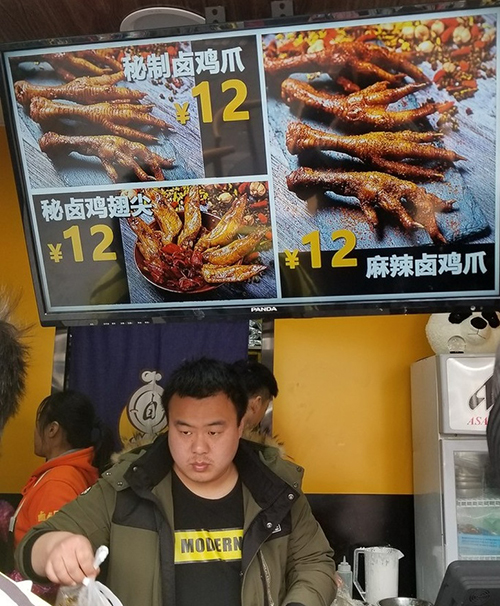 Với người châu Á, ăn chân gà hay đuôi cánh gà là bình thường nhưng trong mắt khách phương Tây thì điều này thật kỳ lạ. Họ tò mò chụp lại một cửa tiệm chỉ bán riêng chân gà và cánh gà sốt cay tấp nập khách hàng.