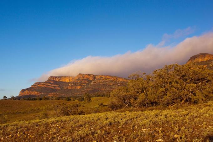 Đi bộ xuyên qua vườn quốc gia Ikara-Flinders Ranges, Australia  Những cặp vợ chồng cá tính sẽ muốn một kỳ nghỉ tại khu bảo tồn Arkaba. Đây là vùng đất hẻo lánh ở Australia đặc trưng với những bụi cây thấp, với bán kính hơn 200 km về phía Bắc Adelaide thuộc miền Nam Australia.  Từ đây, du khách bước vào chuyến đi ba ngày tại Arkaba. Hành trình sẽ xuyên qua Vườn quốc gia Ikara-Flinders Ranges. Hãy thử xem qua Wilpena Pound, vùng đất bằng phẳng được hình thành bởi 500 triệu năm xói mòn và tận hưởng những bài hát ru ban đêm từ vẹt, chim cổ vàng dưới trời sao. "Rất khó để hiểu hết về vùng đất rộng lớn Arkaba", ông Brendon Bevan, người quản lý chung của khu bảo tồn, nói. "Du khách được sống trong tự nhiên và tìm thấy chính mình trên chuyến đi tìm hiểu địa chất dài ngày". Ảnh: David Foster.