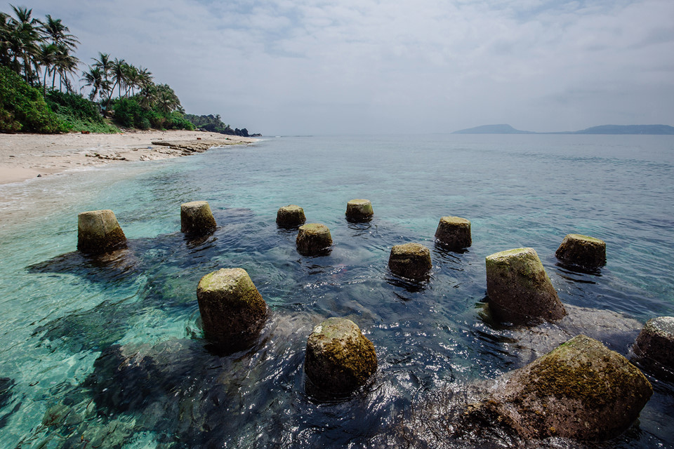  Quanh đảo Bé được trồng nhiều dừa, loại cây đặc trưng của miền biển. Trên bãi biển xanh trong trải dài, nhấp nhô những vách đá trầm tích núi lửa với hình dáng lạ kỳ.