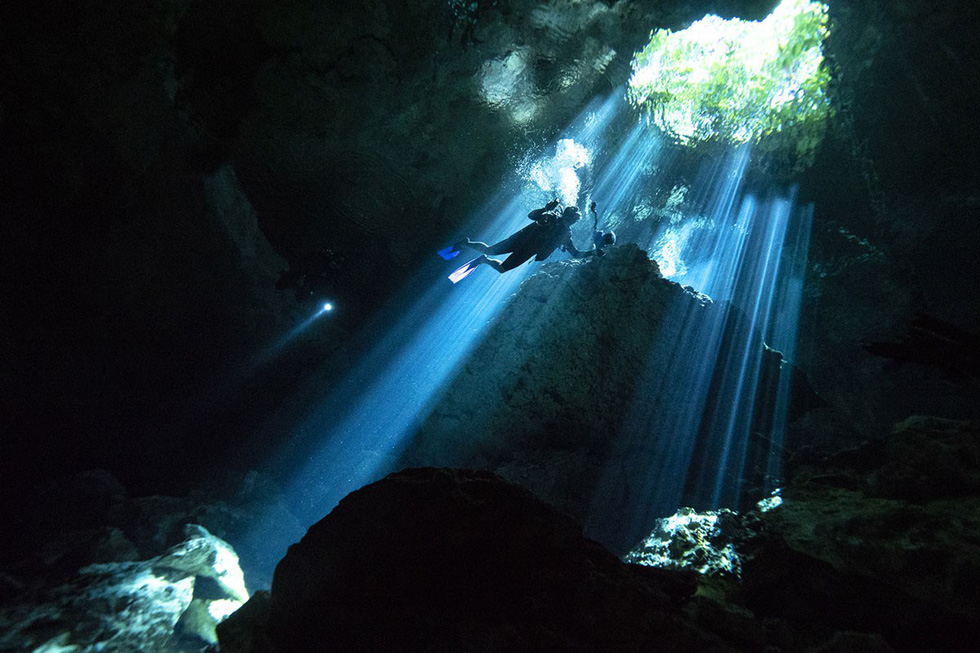 Một thợ lặn bơi dưới hang ngầm đang hướng về phía ánh nắng rọi xuyên qua bề mặt nước của hố sụt tự nhiên Taj Maha tại bang Quintana Roo - Ảnh: Donald Miralle/Getty/Lumix Một thợ lặn bơi dưới hang ngầm đang hướng về phía ánh nắng rọi xuyên qua bề mặt nước của hố sụt tự nhiên Taj Maha tại bang Quintana Roo - Ảnh: Donald Miralle/Getty/Lumix