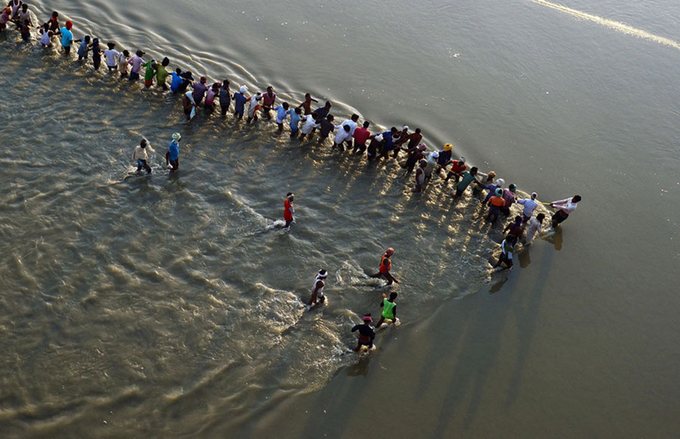 Những chiếc phao thép được kéo ra sông bằng dây thừng. Ảnh: Sanjay Kanojia/AFP.